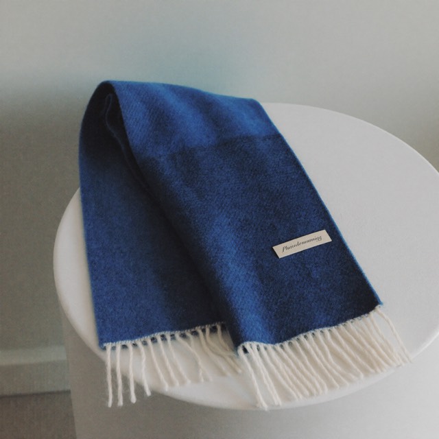 Folded cobalt merino scarf on porcelain linen